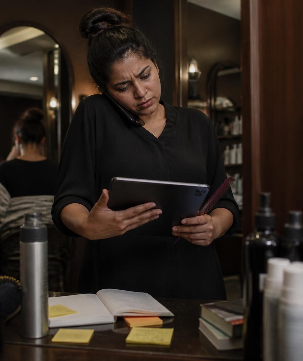 Beauty professional juggling phone calls, messages and paperwork between clients